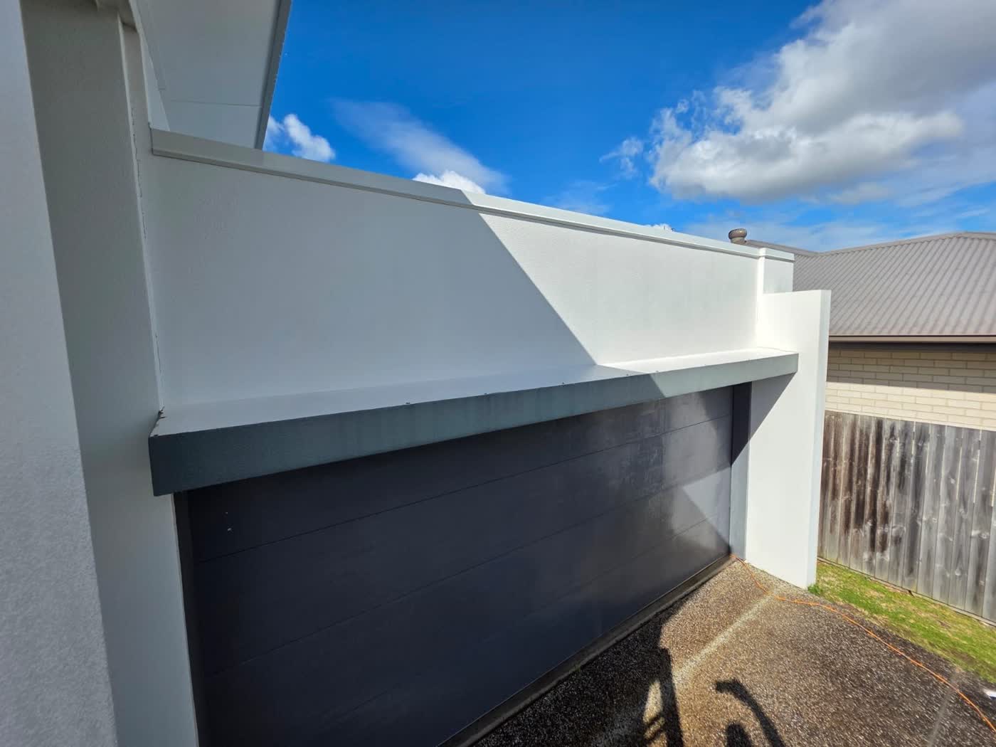 Rendered house wall soft washed to remove mould and red algae staining — after